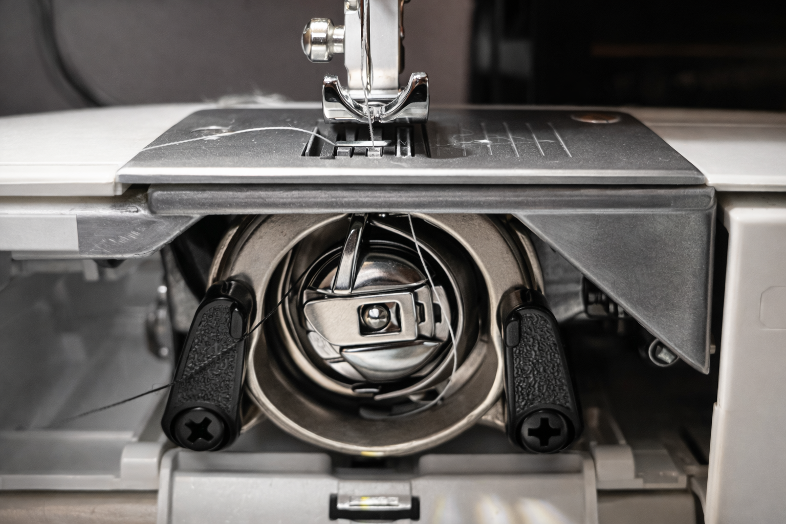 Close view of a sewing-machine bobbin and mechanical assembly